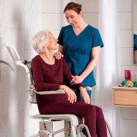 Etac Swift Mobil-2 Shower Commode Chair worker and client